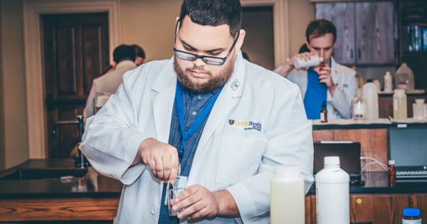 A Gatton College of Pharmacy student in the compounding lab, working on mixing medication