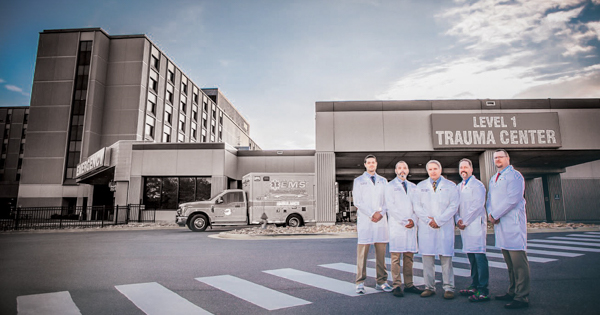 A photo of physicians in white coats standing in front of the Level 1 Trauma Center.