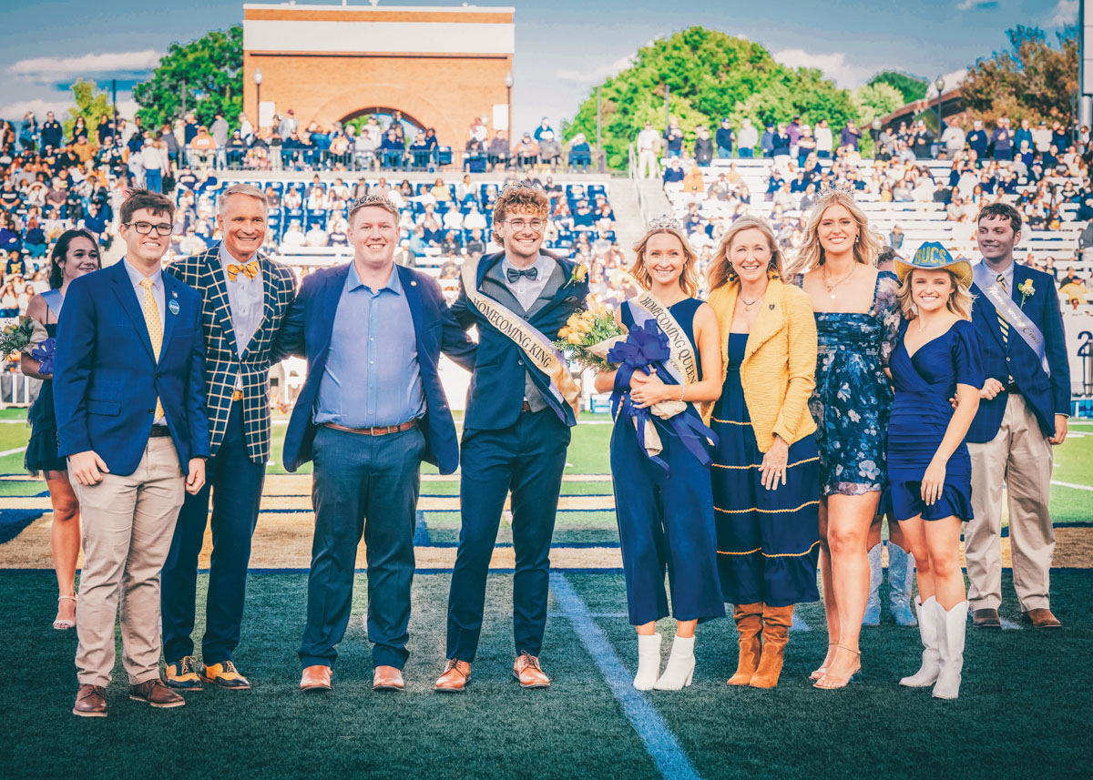 A photo of the ETSU Homecoming Court with President and Mrs. Noland on the football field.