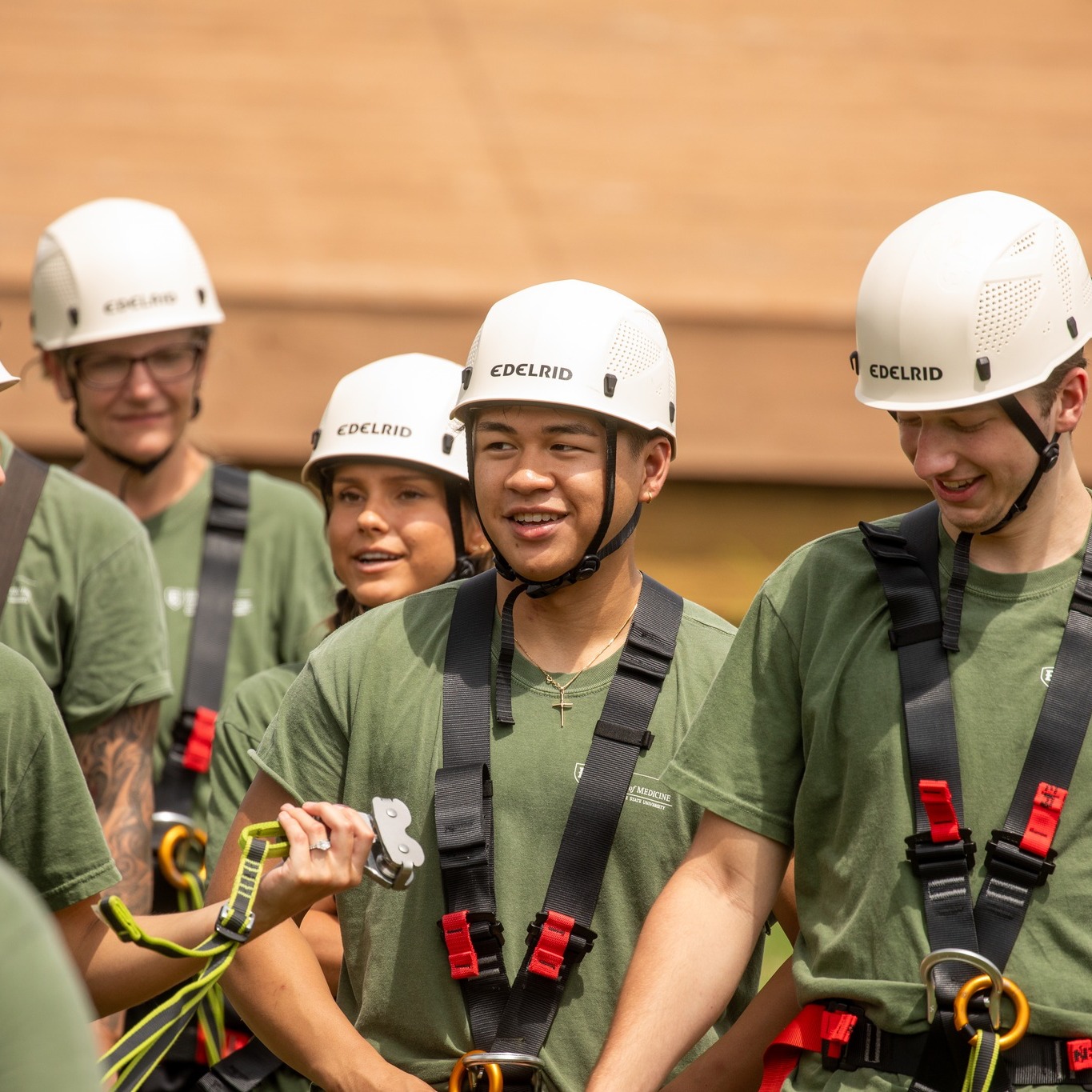 Medical students at orientation at the ropes course, smiling and laughing together.