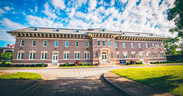 Bishop Hall exterior surrounded by a blue sky full of clouds