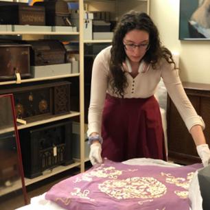 Volunteer interacts with textile artifact