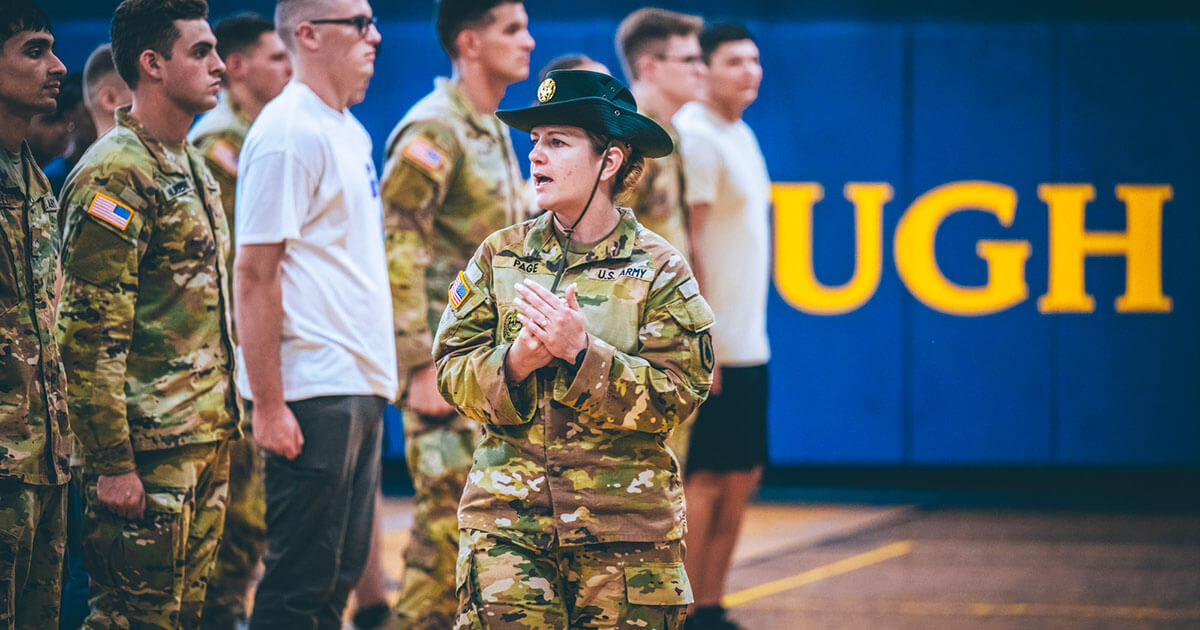 Group of ROTC students at attention listening to instructor