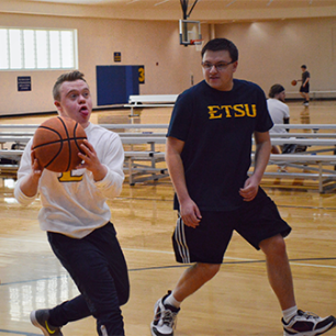 Access student playing basketball with other students
