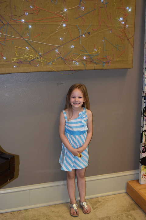 young girl poses with artwork