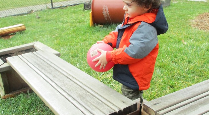 boy plays with ball outside