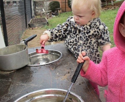 child "cooking" in outdoor kitchen
