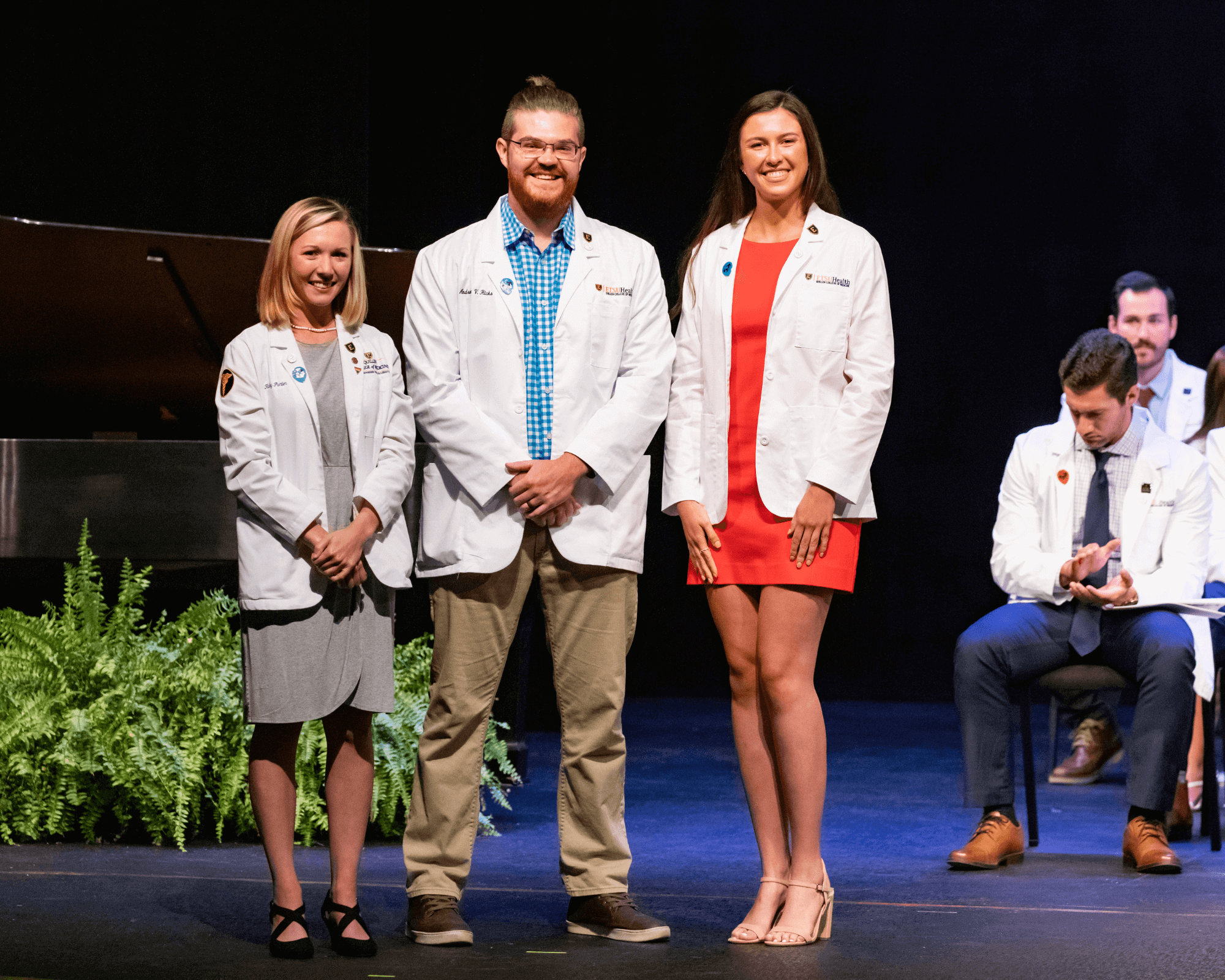 Three medical students pictured together in their new white coats.