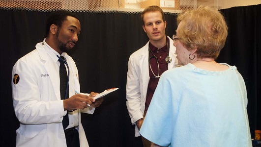 Medical students discussing medicine with a patient.