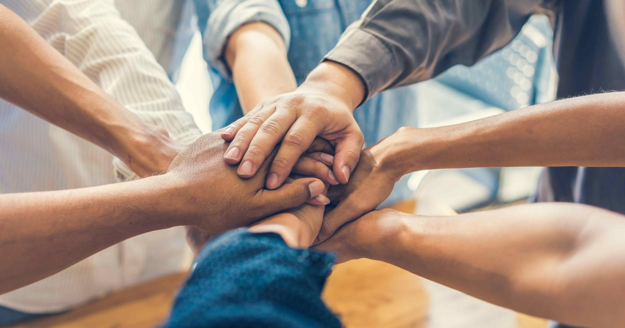 A scene of people putting their hands together.