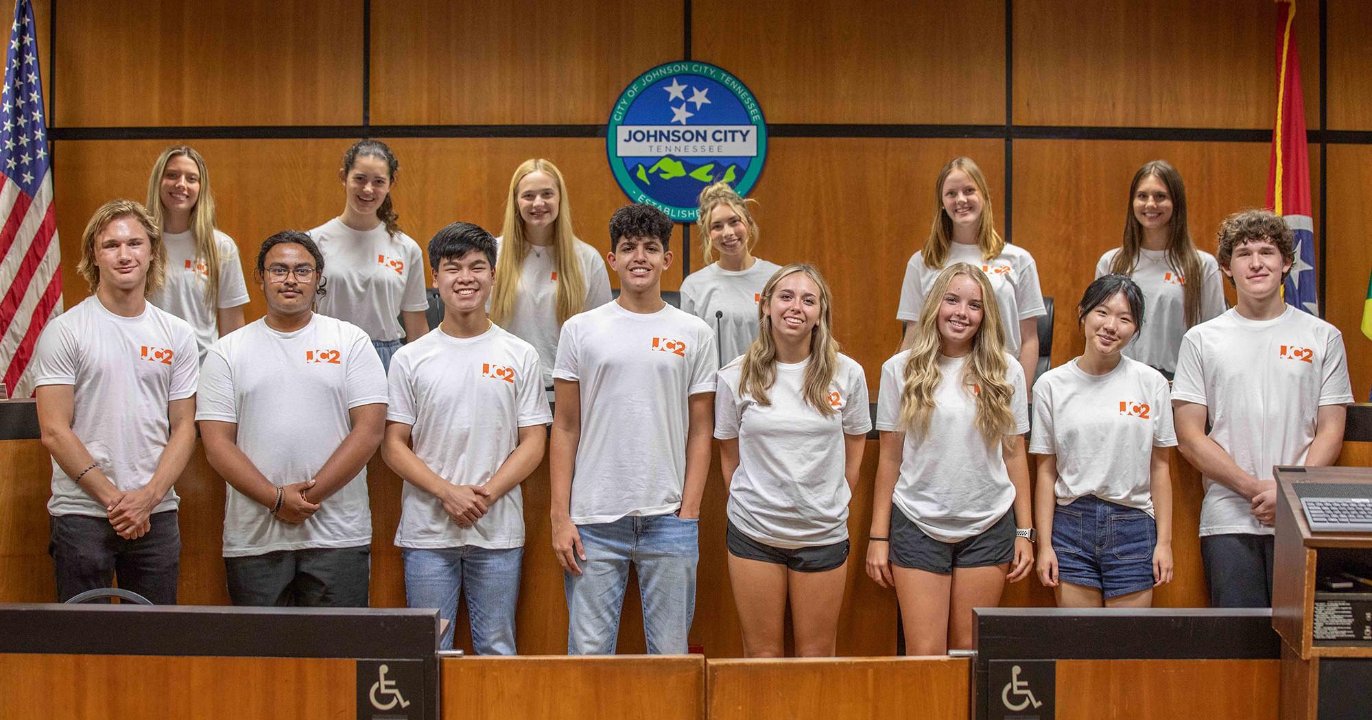 This group shot features the inaugural members of the Johnson City Junior Council and the six ETSU Roan Scholars serving as their mentors, pictured in the Johnson City Commission chamber. Front row, left-right, are Junior Council members Felix Duncan, Abhradeep Chanda, Aaden Nguru, Akshay Vashist, Addison Pumphrey, Ensley Baker, Amy Li and Owen King. Back row, left-right, are Roan Scholars Reagan Sparks, Eliza Smith, Maggie Martin, Olivia Nothnagel, Nora Noneycutt and Shelby Koerten. (Photo contributed by Johnson City Communications and Marketing)