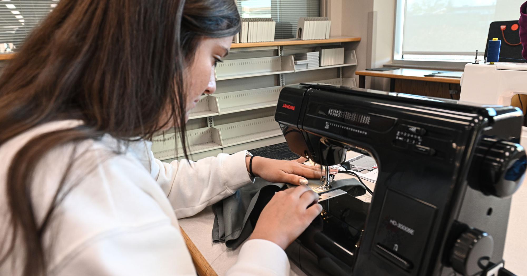 An ETSU student sews in the new Innovation Commons.