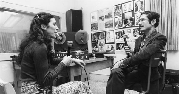 Old photography of two students in the original WETS-FM studio.