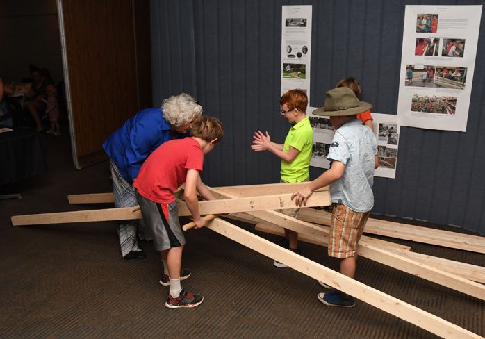 teacher helping children build a bridge