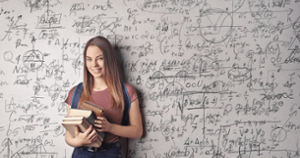 Student in front of a whiteboard with writing on it